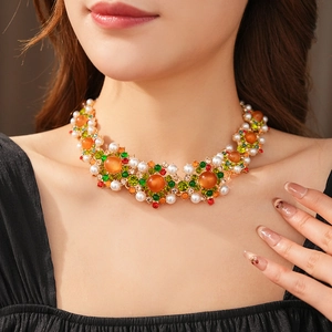 Détail macro d'un collier vintage de luxe avec gemmes orange et perles sur un modèle