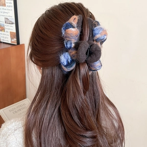 Detail of blue and brown woven flocking bow hair claw clip worn by a model on hair