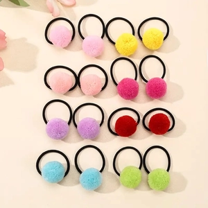 Flat lay of 16 colorful plush pom pom hair ties set with elastic bands for kids
