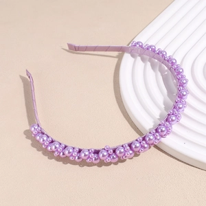 Detail of elegant purple faux pearls in various sizes on a satin wrapped headband