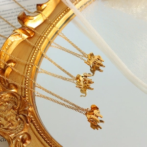 Elegant 18K gold-plated elephant pendant necklace for women on a vintage mirror