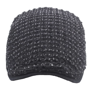Close-up of dark grey tweed flat cap showing textured woven fabric and stitched brim