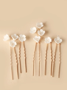 Detail view of 6-piece bridal hair pins with white ceramic flowers and crystal accents
