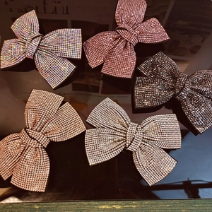 Detailed view of rhinestone bow clips in silver, pink, black, and champagne gold colors