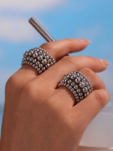Detail of silver multi-layer beaded stacking rings with high polish finish worn outdoors