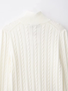 Close-up of thick cable knit texture on the collar of a white turtleneck sweater