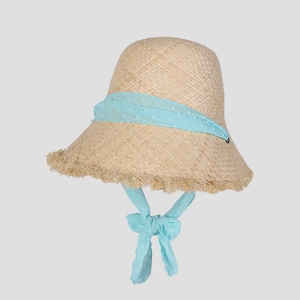 Detail of raffia sun hat featuring light blue swiss dot chiffon ribbon and fringe edges