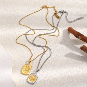 Détail des colliers avec pendentif soleil carré en finitions dorée et argentée