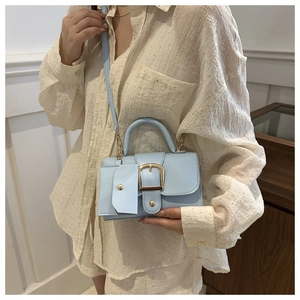 Detail of light blue PU leather handbag with gold buckle and matching coin purse accessory