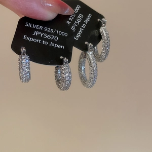 Detail of 925 silver U-shaped hoop earrings with zircon pavé setting on display card