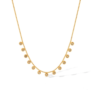 Close-up of gold beaded necklace featuring bezel-set round clear zircon stone pendants