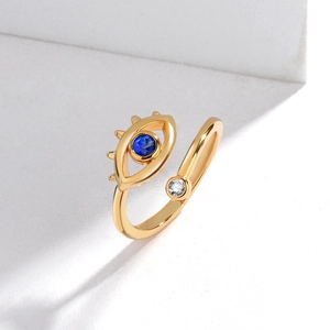 Detail of gold evil eye open ring featuring a blue crystal and eyelash design