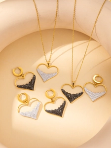 Details des Herz-Schmucksets mit Goldrahmen und schwarz-weißer Diamant-Pavé-Füllung