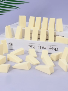 Macro shot of 50-piece cream triangle powder puffs on a minimal decorative background