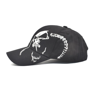 Detail view of black baseball cap featuring side white skull pattern embroidery and classic seams