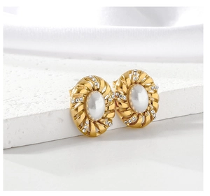 Makroaufnahme der Vintage Gold-Ohrringe mit weißer Perle und funkelnden Strasssteinen