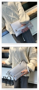 Detail van zilveren clutch van generfd leer met ritssluiting en polsbandje