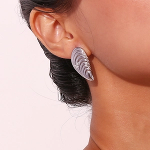 Boucles d'oreilles coquillage en argent avec perles blanches sur un modèle