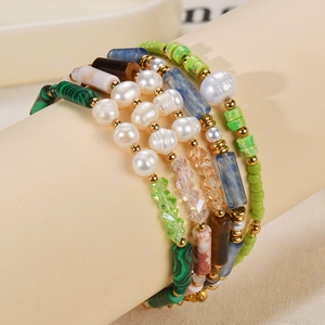 Handmade multilayer bracelet with natural pearls, blue stones, and green crystals on display