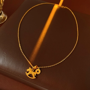 Detail shot of gold-plated pony and coin pendant necklace on premium leather