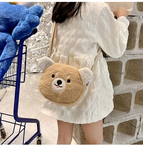 Child wearing brown and white teddy bear plush crossbody bag shown from a back side view