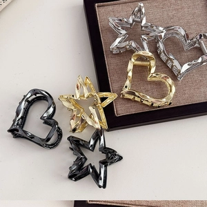 Minimalist geometric metal hair claws with heart and star shapes in various metallic tones