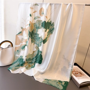 Détail d'un foulard en satin de soie avec imprimé lotus élégant sur support en métal