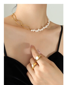 Detail of French vintage baroque pearl necklace and gold rings worn by a model
