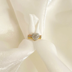 Three-tone layered stackable ring set with heart-shaped pave crystals on white silk