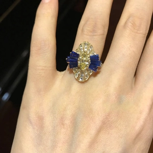 Close-up of vintage 18K gold ring with yellow marquise zircon and blue baguette sapphires