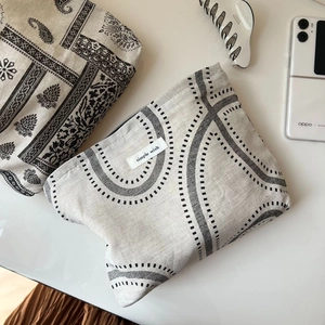 Detailed macro of vintage paisley and wave patterns on cotton linen fabric storage pouches