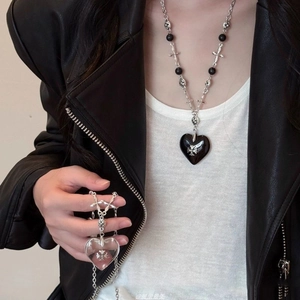 Close-up of stone beaded necklaces with heart pendants and metallic cross charms