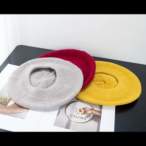 Detailed knit texture of beret hats in grey, burgundy, and yellow colors