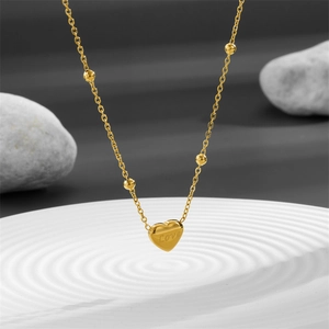 Elegant gold titanium heart necklace with Love engraving and beaded chain detail