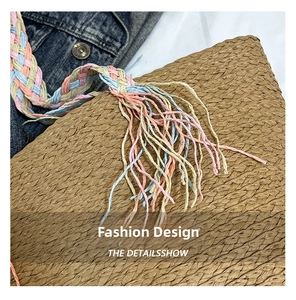 Dettaglio borsa in paglia intrecciata con spalline colorate e nappe in stile boho
