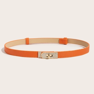 Close-up of orange Saffiano leather skinny belt with crystal-studded gold turn-lock buckle