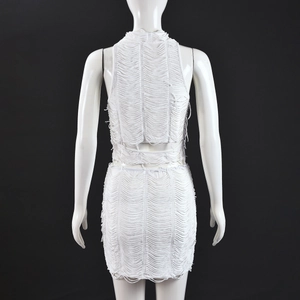 Dettaglio del vestito bianco con frange che mostra la trama intrecciata e il design nudo
