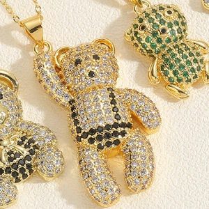 Macro shot of teddy bear pendants with sparkling zircon stones on gold chains