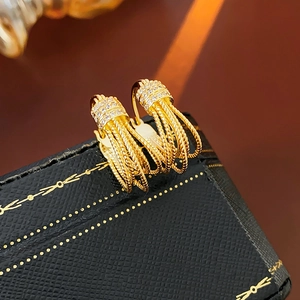 Détail macro de boucles d'oreilles multicouches plaquées or 14K avec zircon brillant