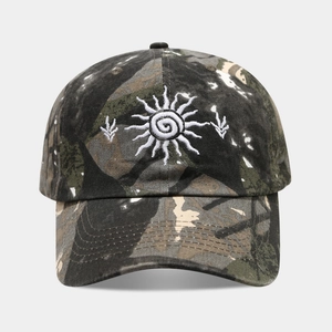 Détail de la broderie soleil et du motif camouflage sur casquette en coton délavé