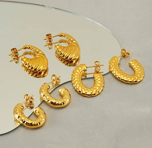 Detailed view of three gold croissant earrings with ribbed and hammered textures