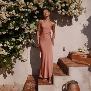 Macro detail of the backless halter neckline and satin texture on the terracotta maxi dress