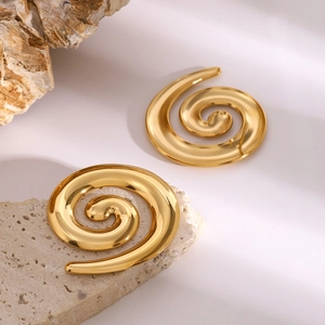 Macro shot of 18k gold plated spiral stud earrings on light stone minimalist aesthetic
