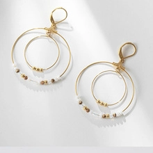 Detail of 304 stainless steel gold-plated twist earrings with decorative beads and lever-back