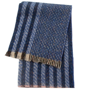 Close-up of blue and brown striped knit scarf with textured fringe tassels