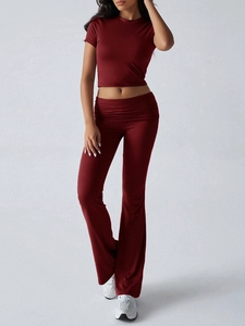 Detail of dark red two-piece set featuring short sleeve crop top and flared yoga pants