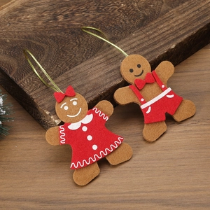 Detail of felt gingerbread man Christmas tree ornaments on a natural wooden surface