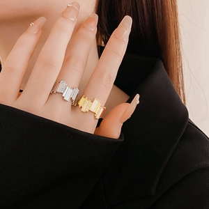 Macro detail of geometric gold and silver rings with zircon stones on a model's hand