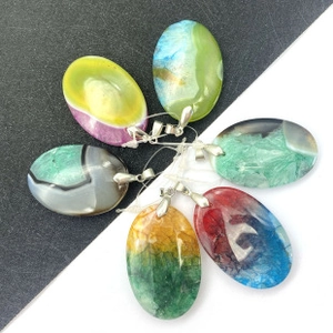 Detail view of colorful fish-shaped natural stone pendants with silver metal clasps
