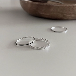 Close-up of 925 sterling silver minimalist rings with smooth and textured stackable bands